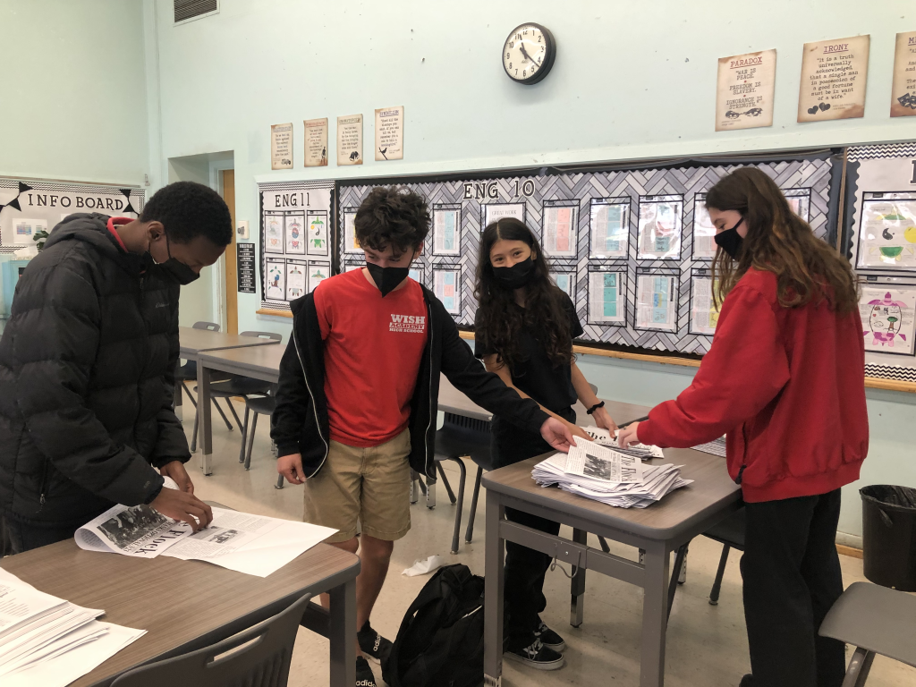 Members of the Newspaper Club fold copies of an issue for distribution